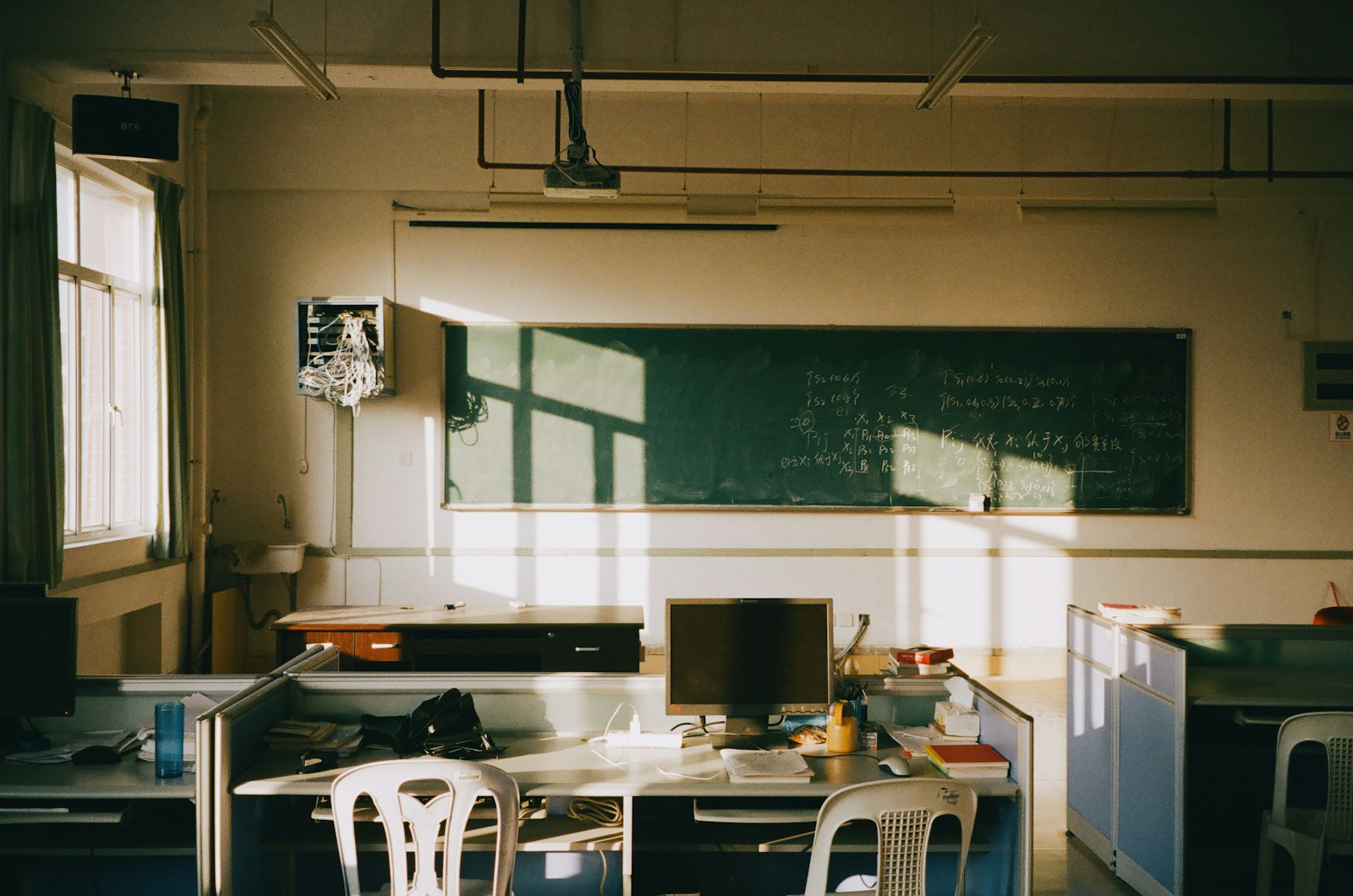 Sunlight streams into an empty classroom with desks
