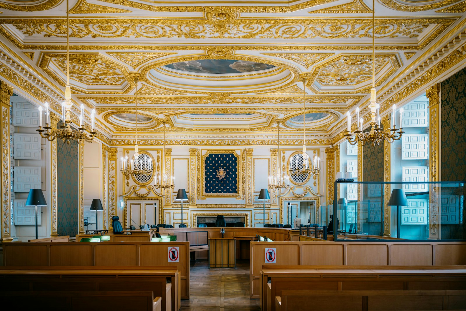 Ornate courtroom with gilded decorations and chandeliers