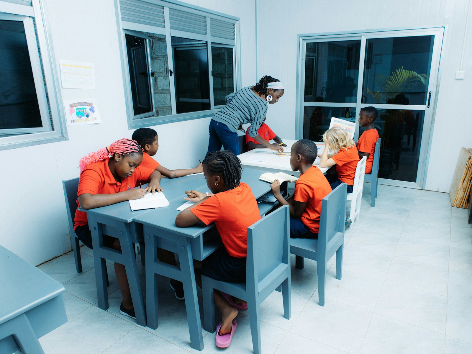 Teacher instructing children at tables in a classroom