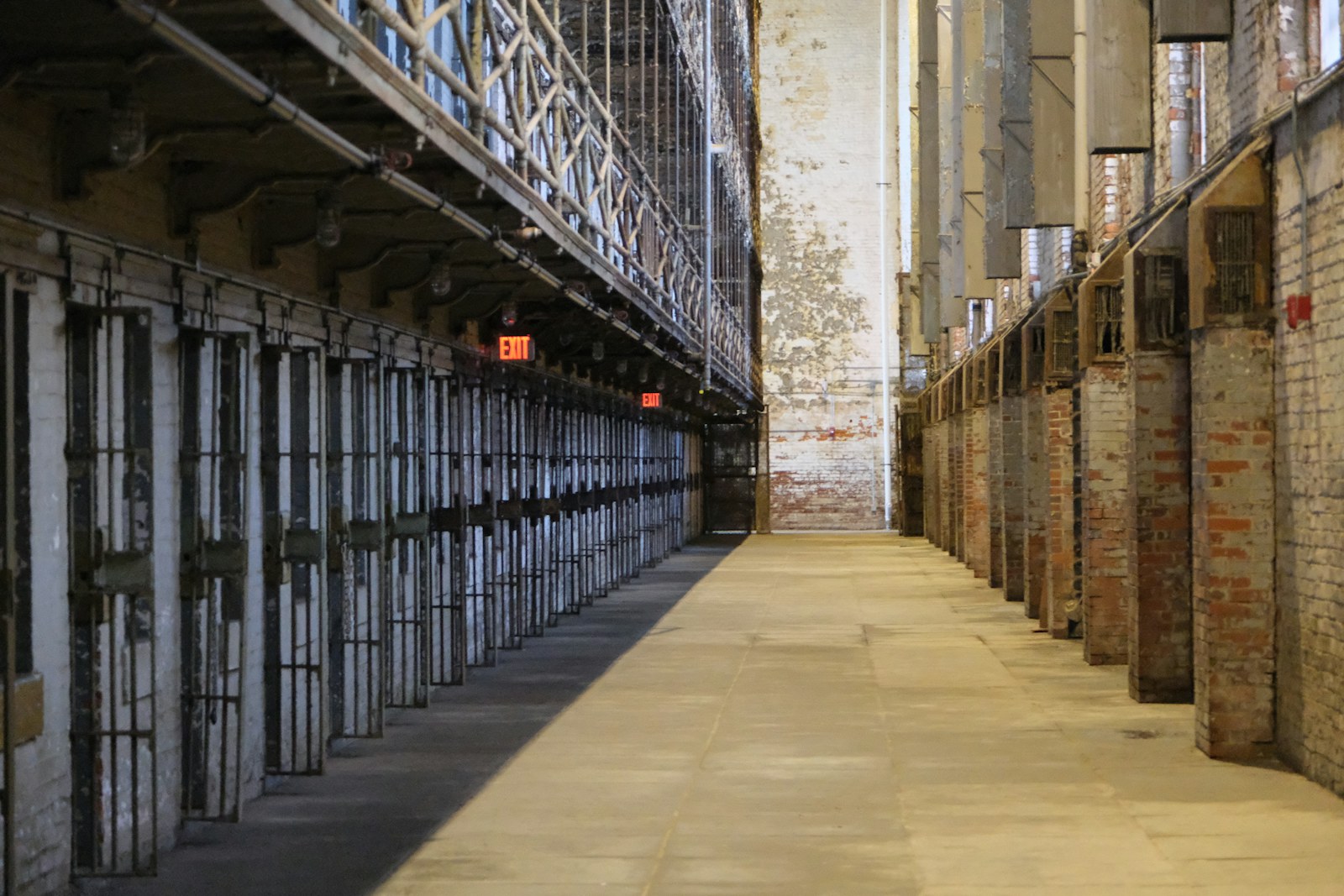 A long hallway with prison cells on the left