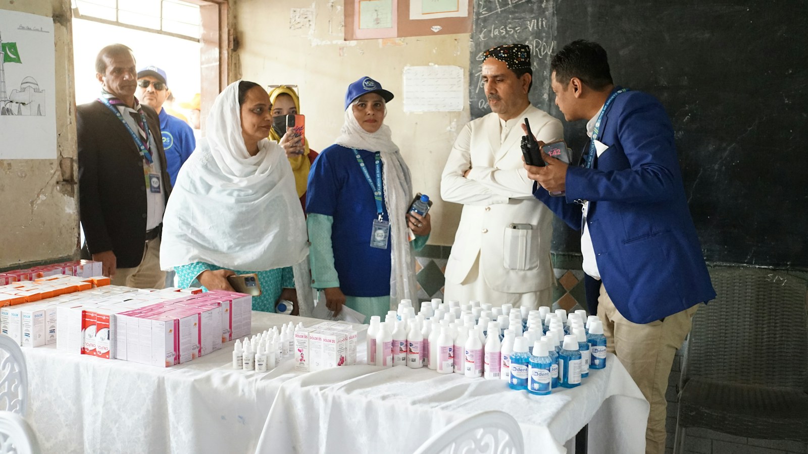 Health workers and officials with medicine bottles on a table
