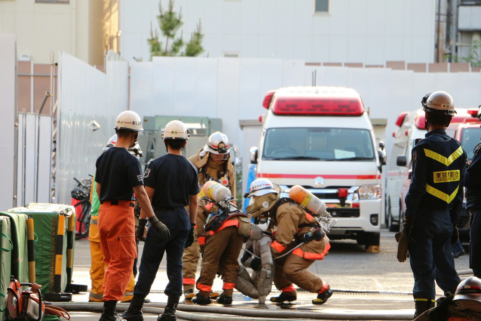 Firefighters in protective gear near an ambulance