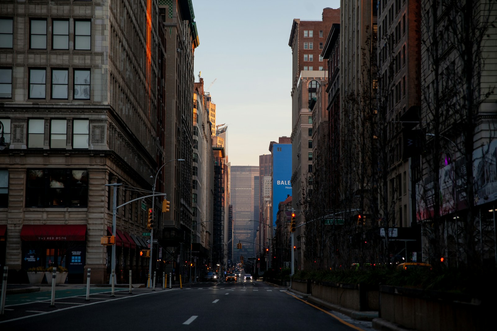 cars on road between high rise buildings during daytime
