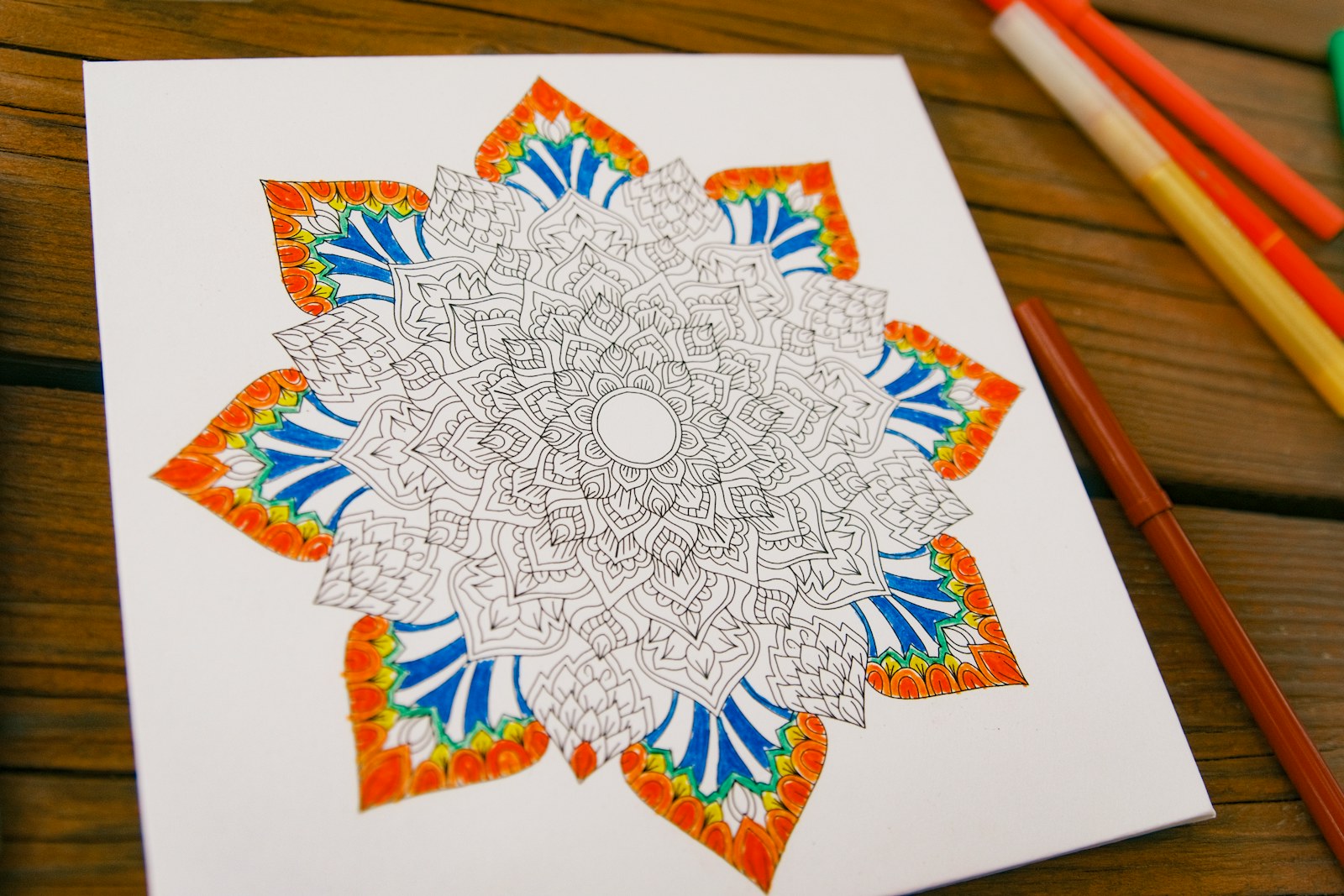 Mandala coloring page with orange and blue details
