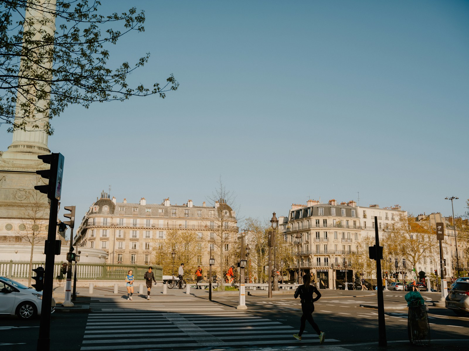 People crossing street in front of parisian buildings