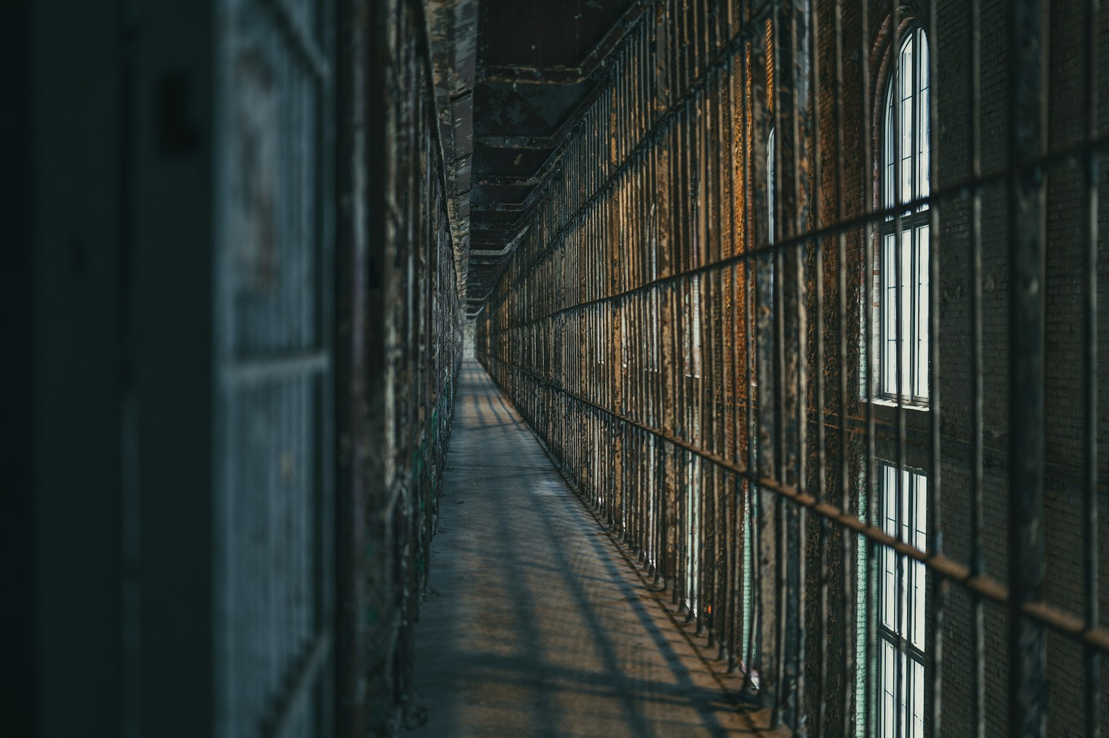 Dimly lit prison corridor with barred cells