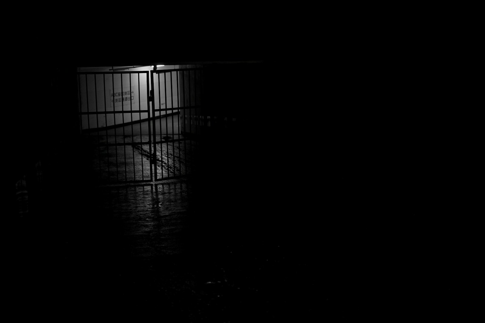A metal barrel sits on a wet surface at night