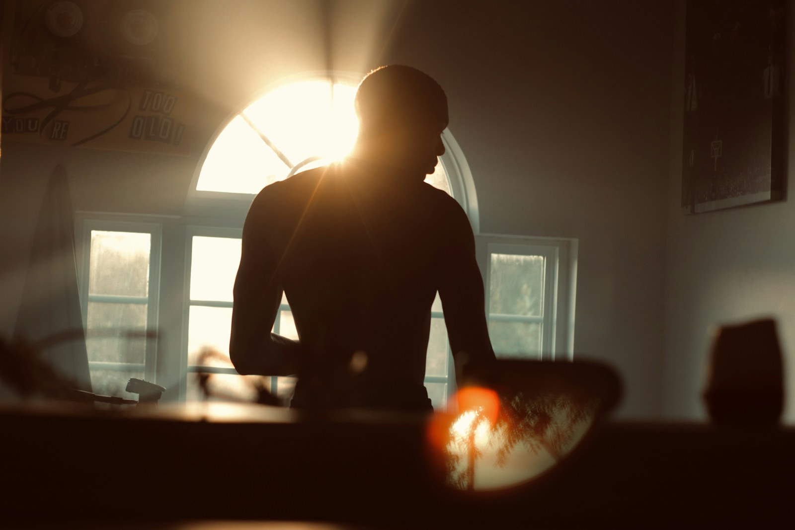 silhouette of man standing near window