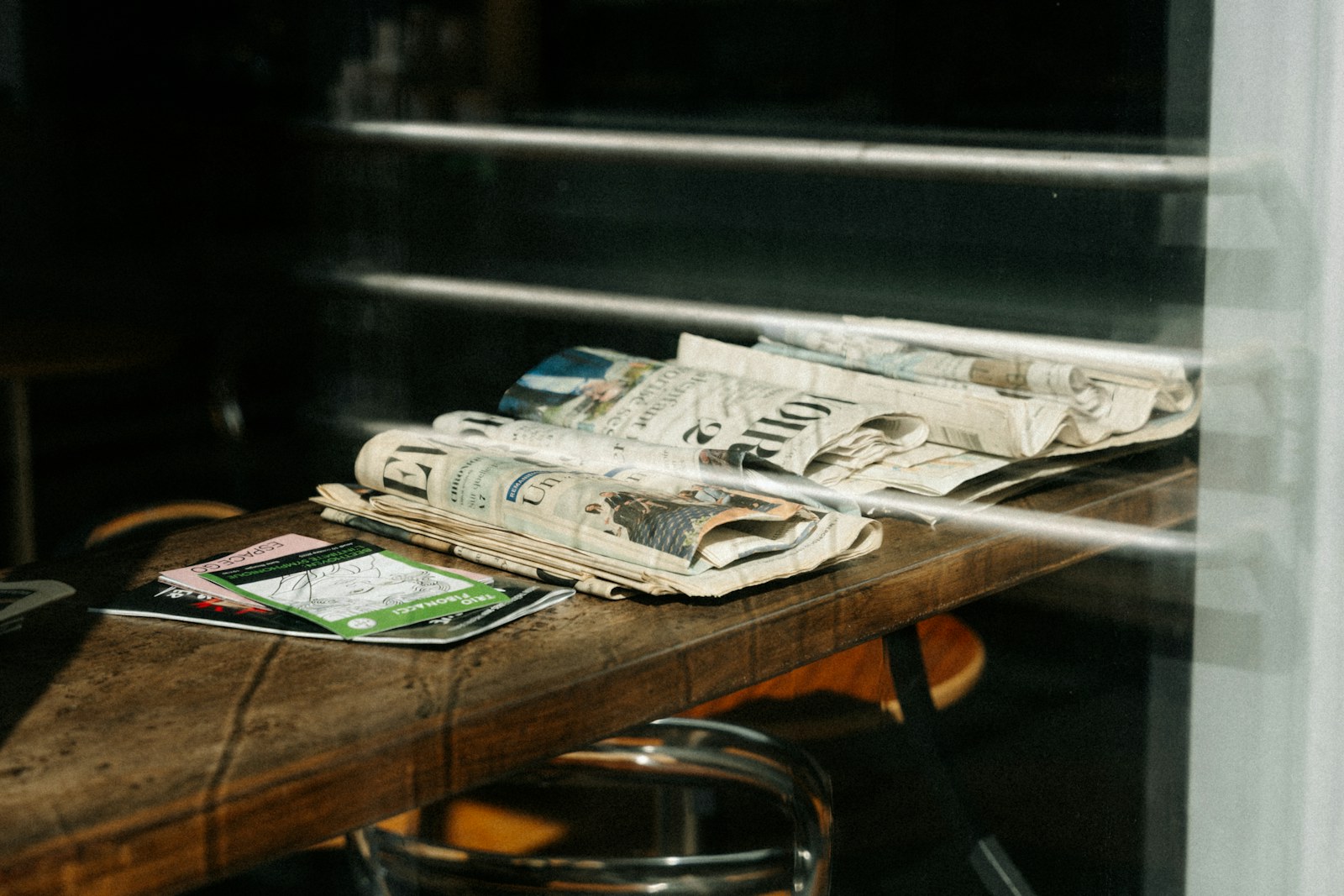 Stack of newspapers and magazines on a wooden table