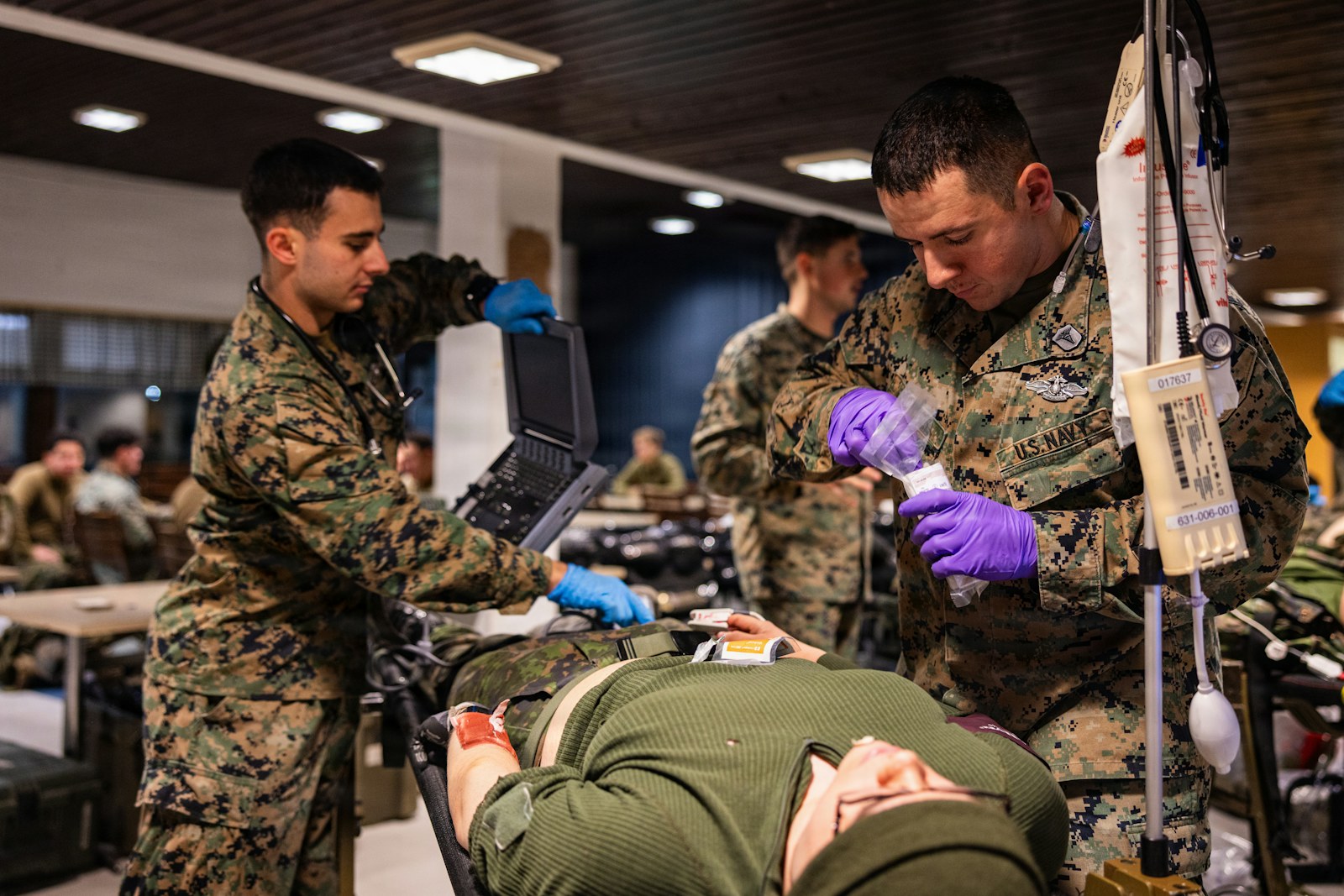 Marines provide medical care to a patient on a stretcher