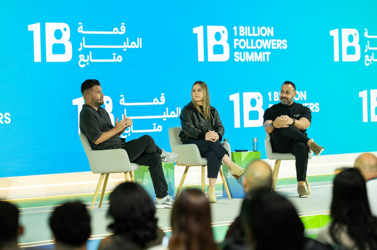 Three people on stage at a summit