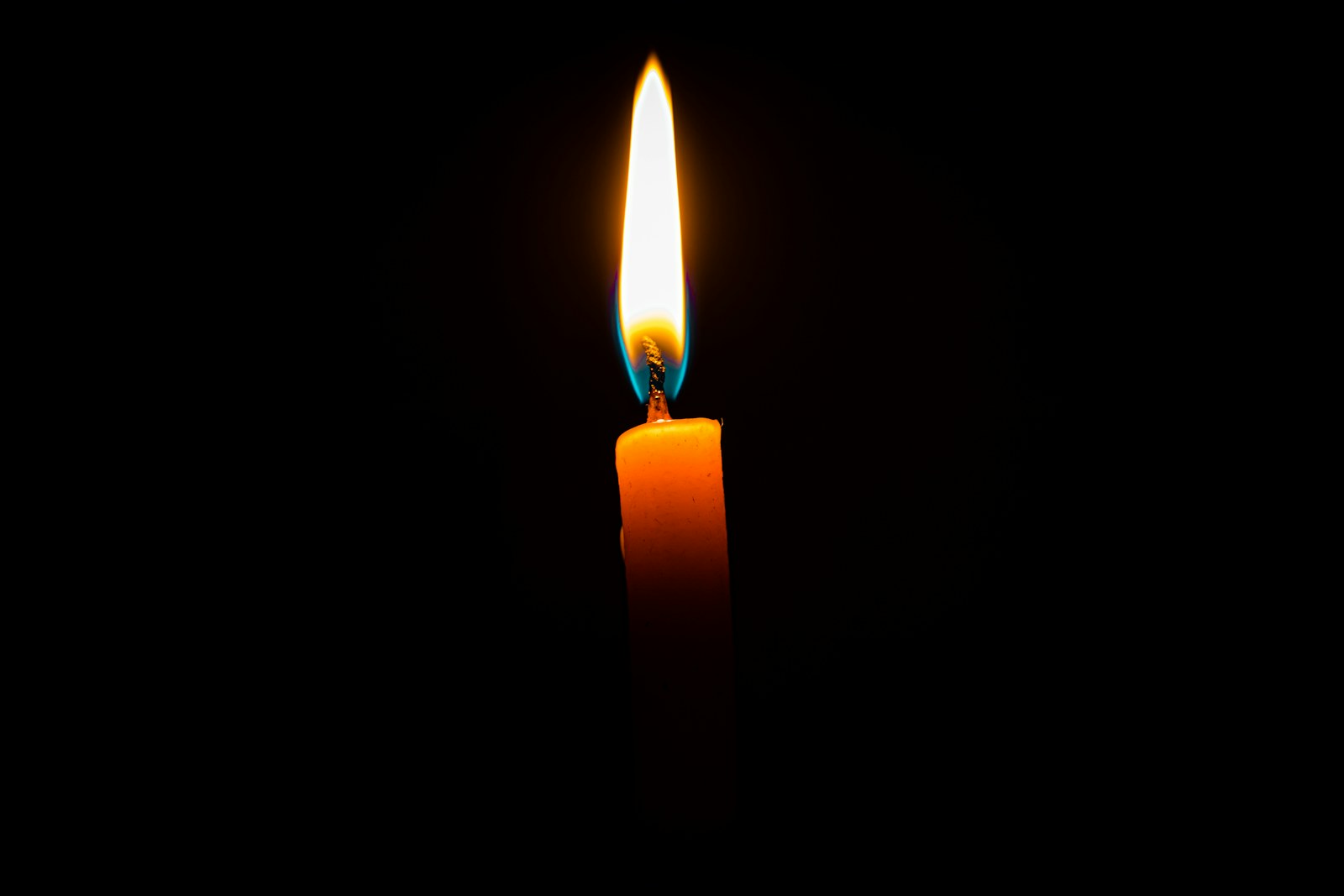 lighted candle in dark room